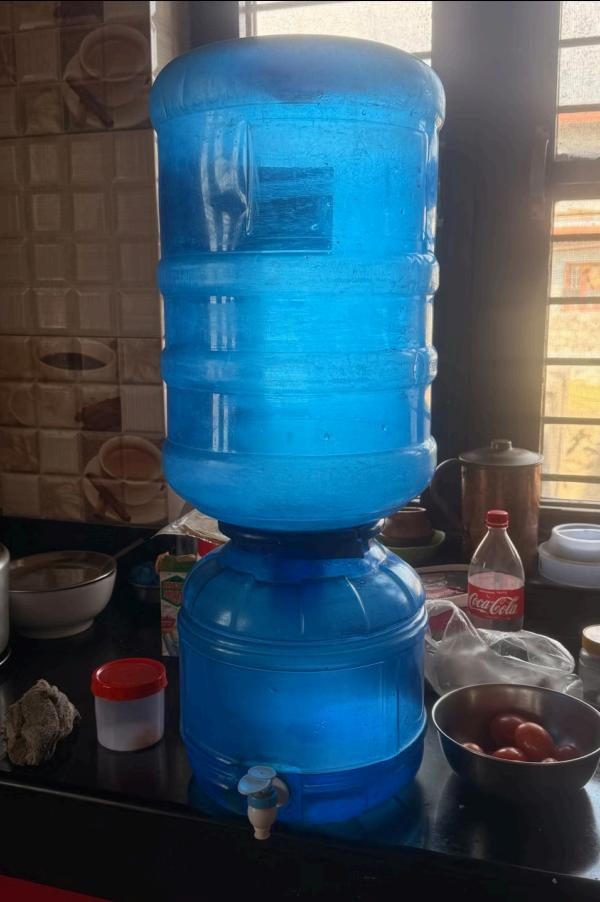 A 20-litre water jar on a dispenser in a Pokhara kitchen